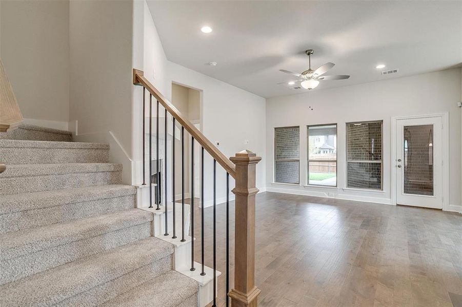 Stairway featuring hardwood / wood-style floors and ceiling fan