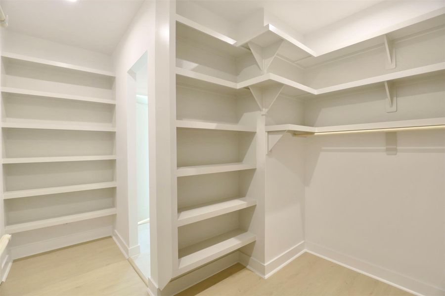 The custom primary closet features floor-to-ceiling floating shelves designed to showcase sneakers, hats, bags, and other accessories, while offering effortless access and a curated display for your wardrobe. The custom primary closet features floor-to-ceiling floating shelves designed to showcase sneakers, hats, bags, and other accessories, while offering effortless access and a curated display for your wardrobe.