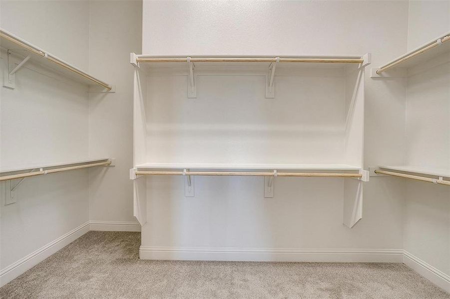 Walk in closet with light colored carpet