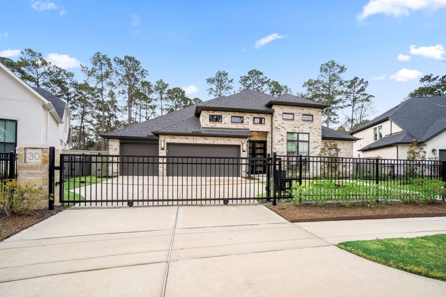 Automatic driveway gate and 3-car garage with epoxy finished floors.