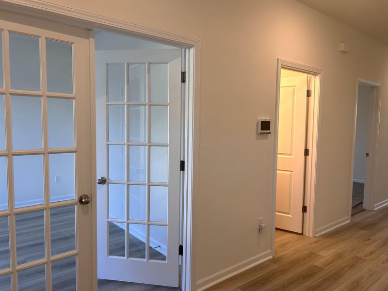 Corridor with light wood-style floors and baseboards