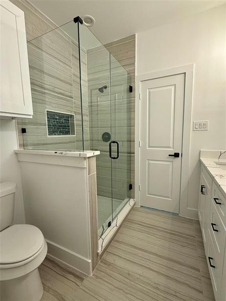 Bathroom featuring a shower stall, vanity, and light wood finished floors