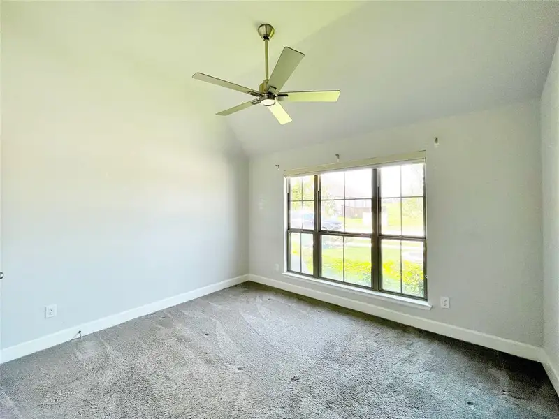 Spare room featuring carpet, a ceiling fan, and high vaulted ceiling Spare room featuring carpet, a ceiling fan, and high vaulted ceiling