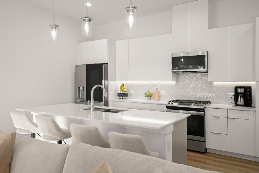 Gorgeous contemporary island kitchen open to the living and dining area with desirable modern finishes. Gorgeous contemporary island kitchen open to the living and dining area with desirable modern finishes.