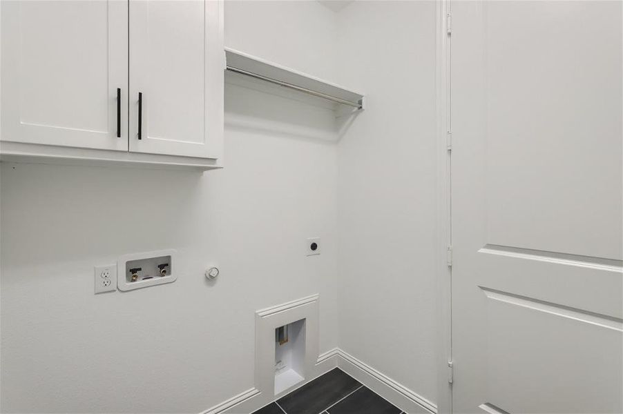 Clothes washing area featuring cabinets, tile flooring, hookup for a washing machine, electric dryer hookup, and hookup for a gas dryer