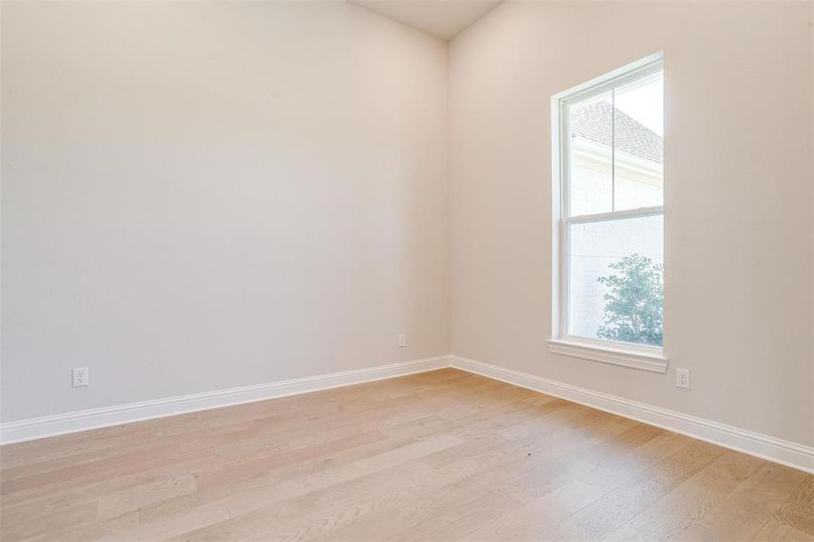 Empty room with light hardwood / wood-style flooring