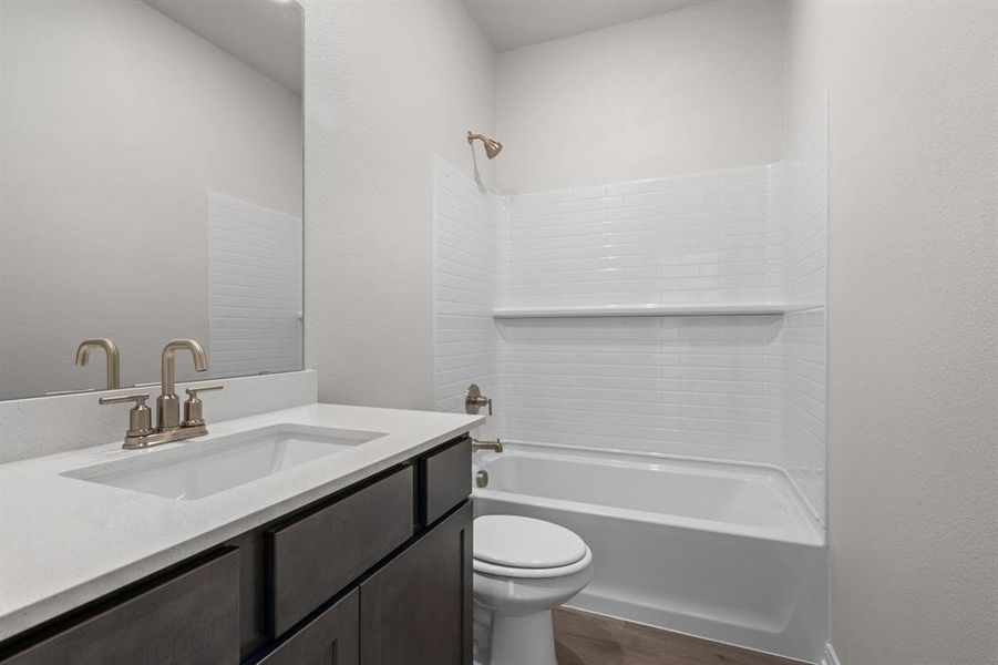 Bathroom with tub / shower combination, vanity, dark wood finished floors, and a textured wall