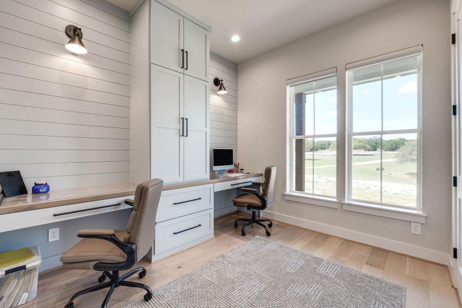 Office space featuring built in study area, light wood-style floors, and recessed lighting