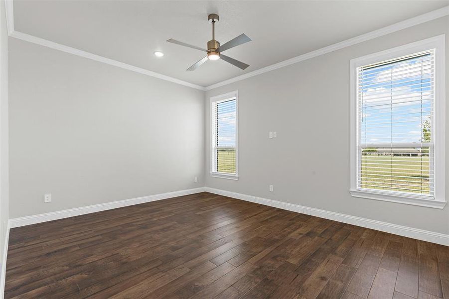 Bedroom with ornamental molding, dark wood-style flooring, a ceiling fan, and recessed lighting Bedroom with ornamental molding, dark wood-style flooring, a ceiling fan, and recessed lighting
