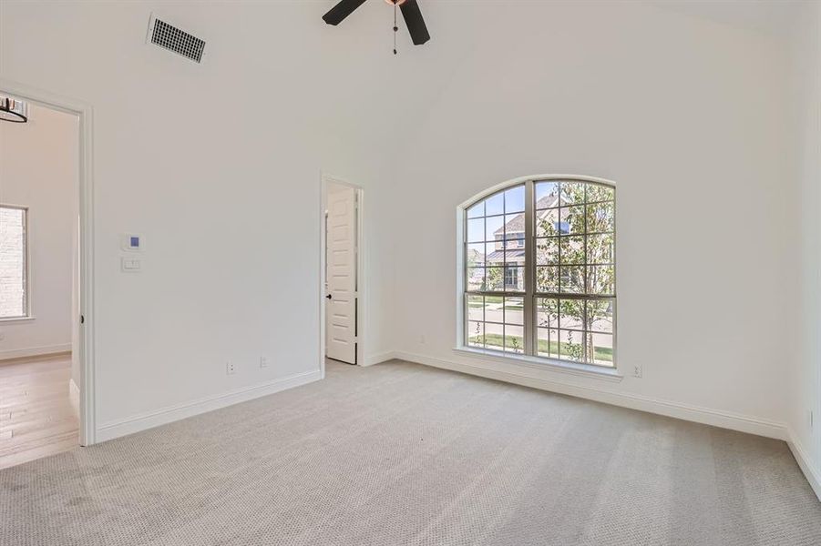 Secondary bedroom with ceiling fan and high vaulted ceiling