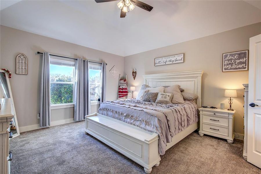 Carpeted bedroom featuring ceiling fan