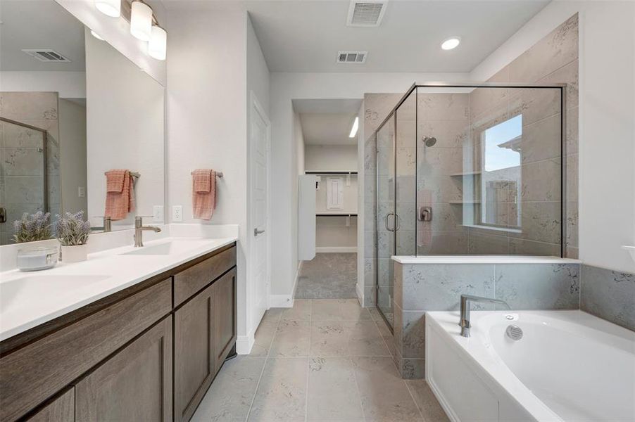 Double vanity with white countertop and wood-finish cabinetry
