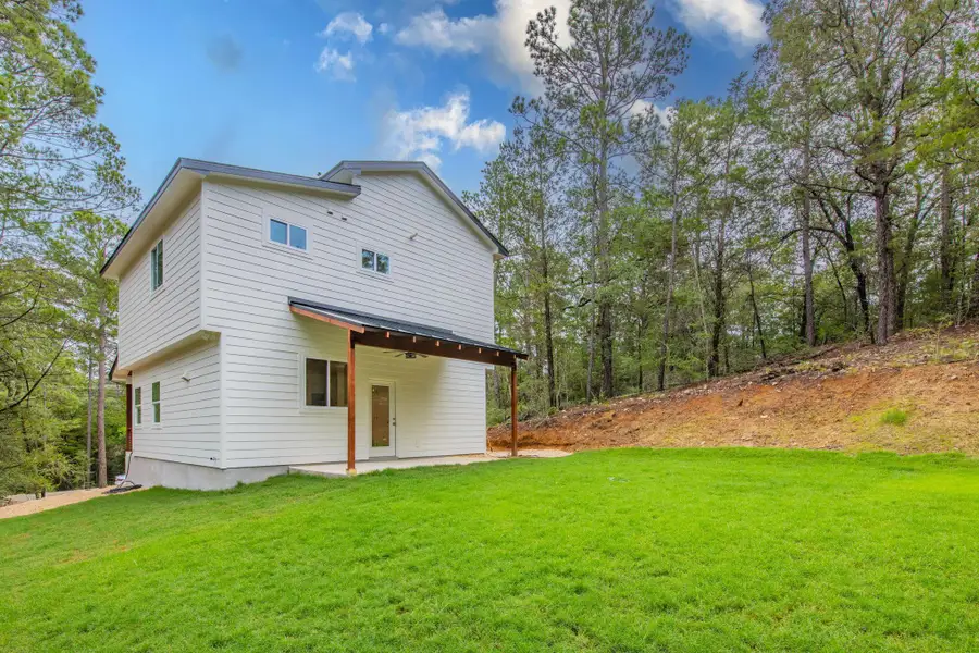 A newly constructed residence nestles against a forested hillside, offering a peaceful, private yard. A newly constructed residence nestles against a forested hillside, offering a peaceful, private yard.