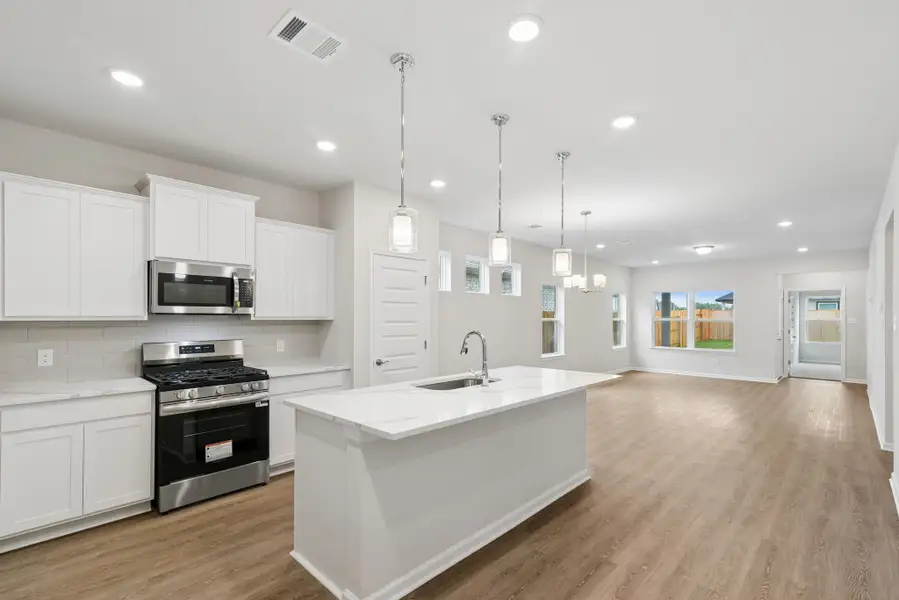The Oakshire II- Kitchen in Dining Area and Family Room.  Sample image for illustration; upgrades, options, and colors may vary.