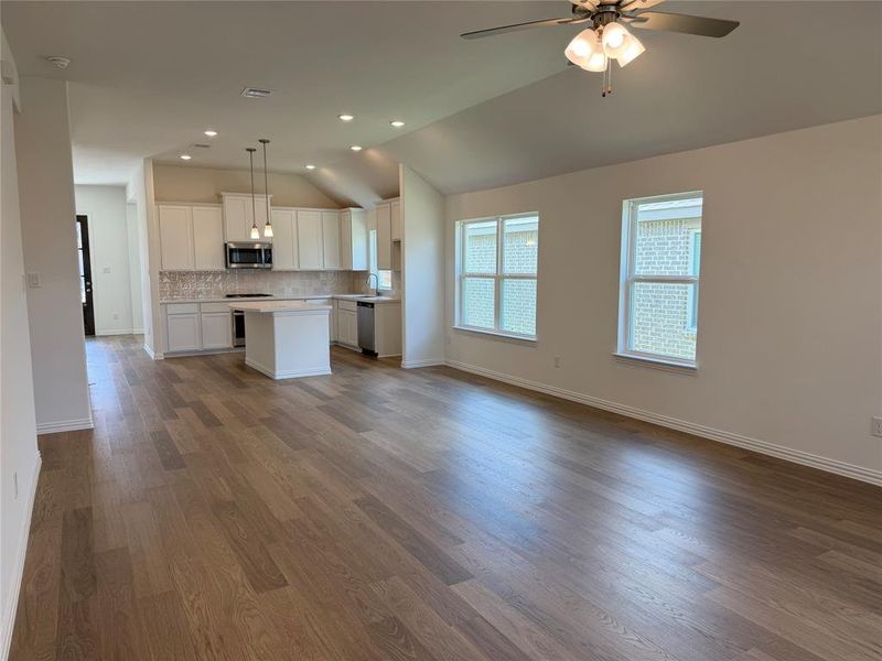Expansive living area featuring wood-finish flooring and a ceiling fan