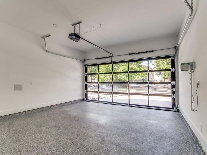 Garage with baseboards and a garage door opener