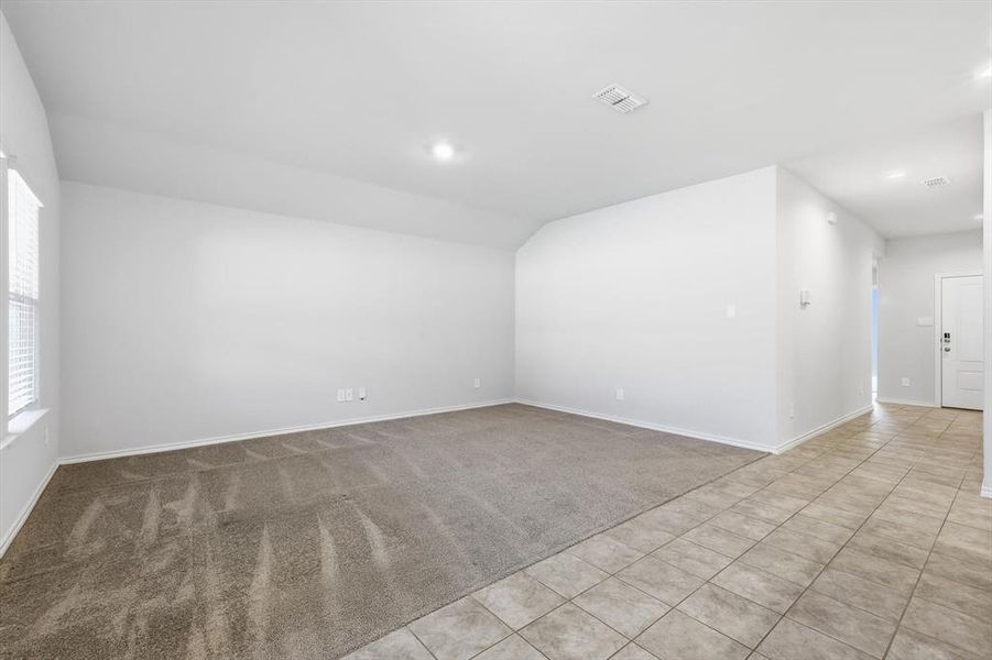 Living area with carpet, recessed lighting and windows across the back Living area with carpet, recessed lighting and windows across the back