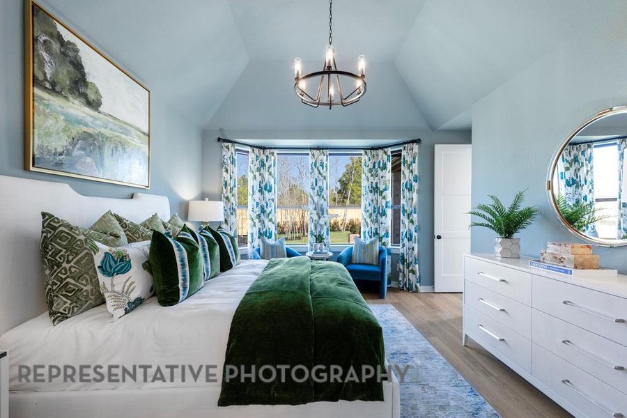 Bedroom featuring a chandelier, wood finished floors, and lofted ceiling Bedroom featuring a chandelier, wood finished floors, and lofted ceiling