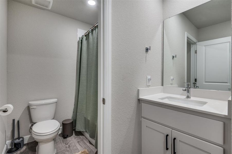 Bathroom with vanity, a textured wall, and light wood finished floors
