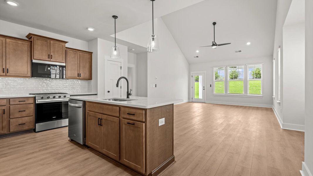 Accomplished kitchen design featuring pendant lighting above a statement island for both prep and gathering