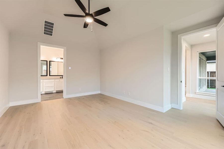 Unfurnished living room featuring light hardwood / wood-style floors, ceiling fan, and a high ceiling