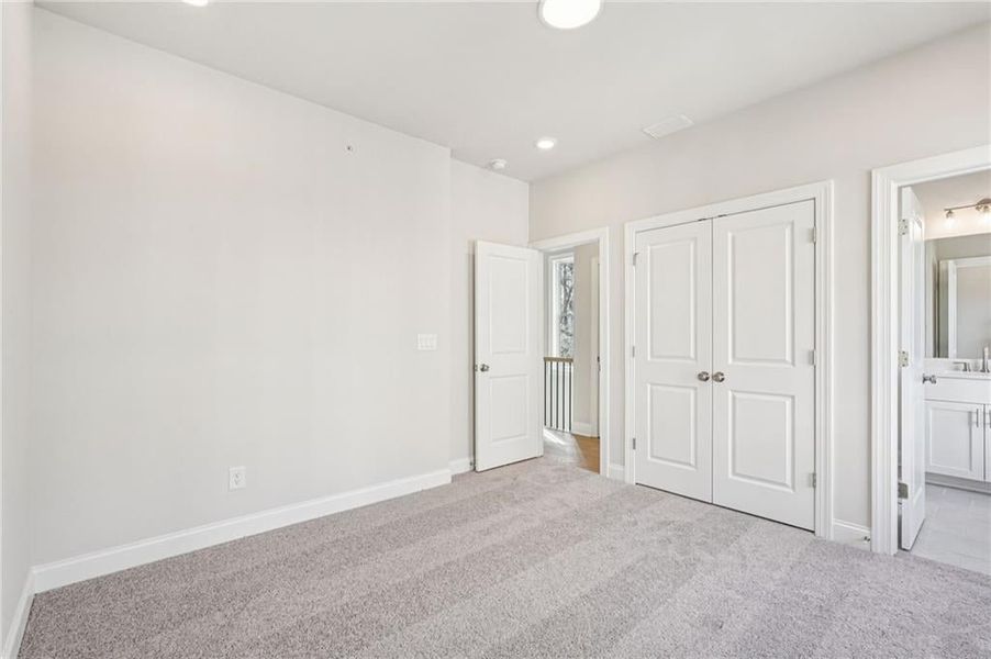 Unfurnished bedroom featuring ensuite bathroom, carpet, a closet, and recessed lighting