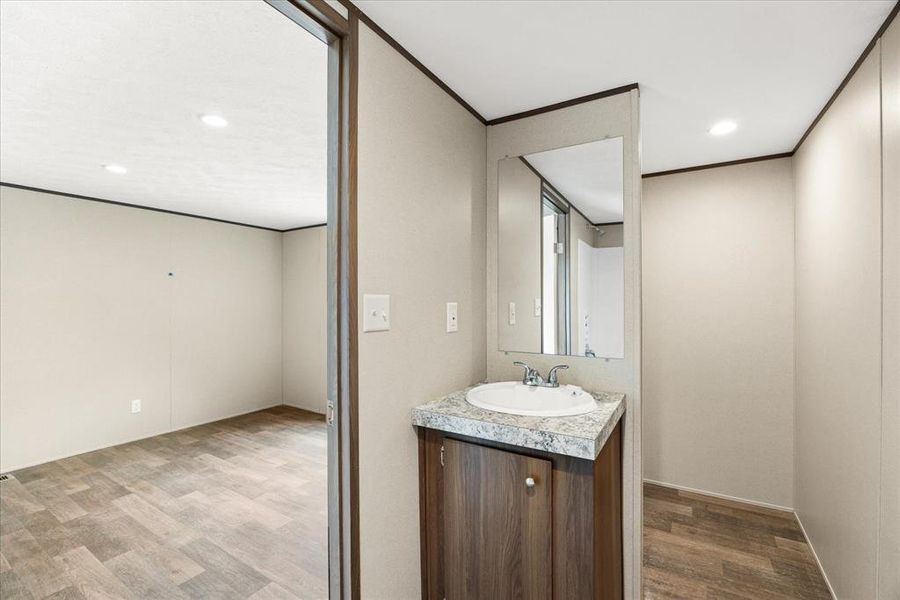 Bathroom vanity featuring a white oval sink, chrome faucet, and a patterned countertop