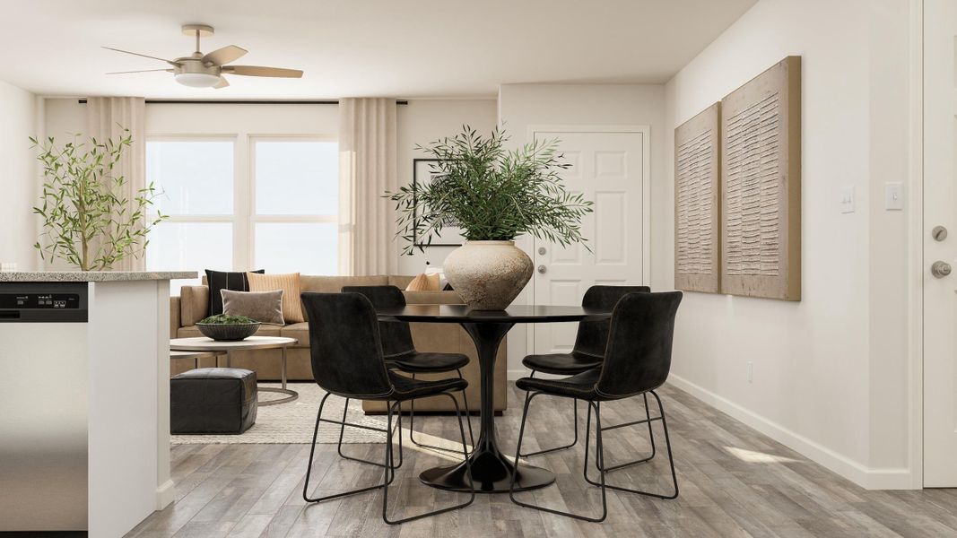 A room with a table chairs and a plant.