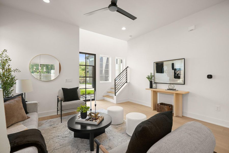 Natural light floods this living area, highlighting warm wood flooring and a clean, modern aesthetic. Natural light floods this living area, highlighting warm wood flooring and a clean, modern aesthetic.