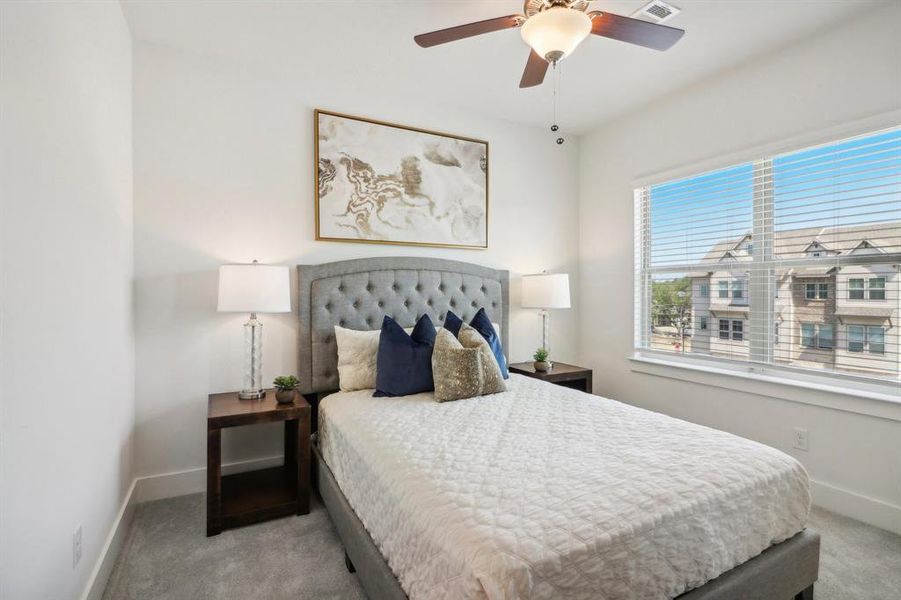 Carpeted bedroom featuring ceiling fan