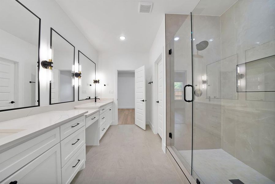 Spacious bathroom featuring a dual vanity with white cabinetry and light-toned countertops Spacious bathroom featuring a dual vanity with white cabinetry and light-toned countertops