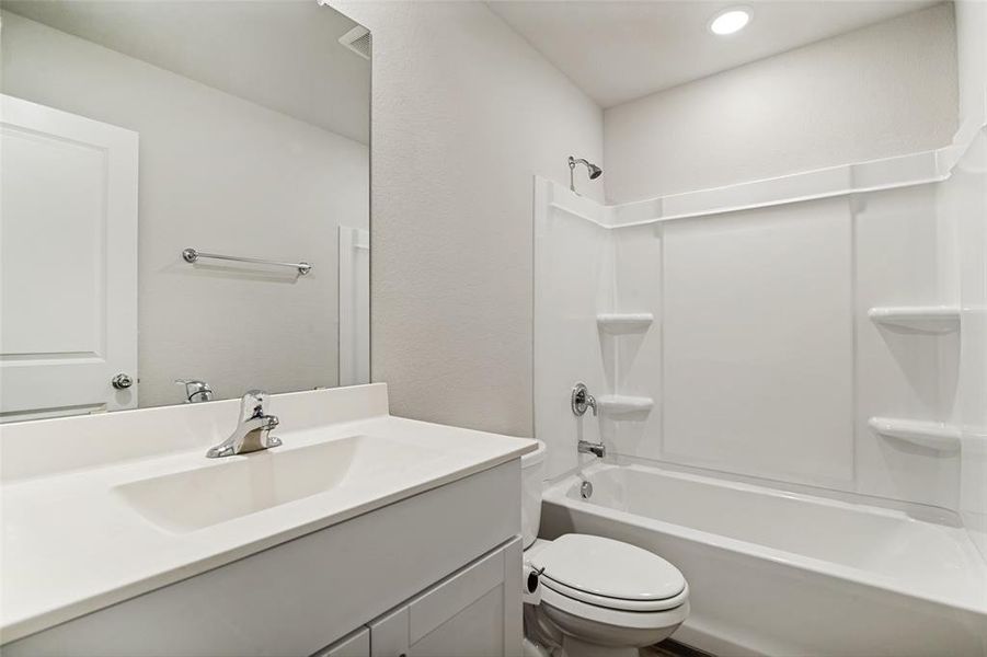 Bathroom featuring a single vanity with an integrated sink, chrome faucet, and a large mirror Bathroom featuring a single vanity with an integrated sink, chrome faucet, and a large mirror