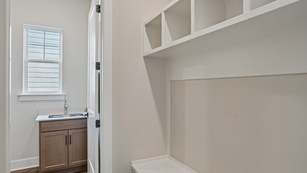 Built-In MDF drop zone with cubbies and bench near laundry room