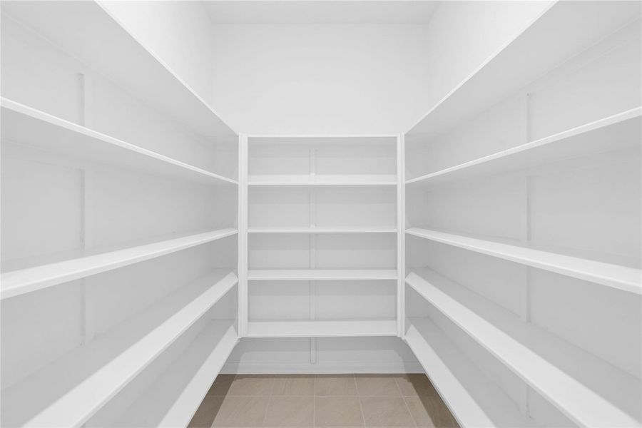 This spacious walk-in pantry featuring built-in shelving provides plenty of room for all your kitchen essentials. This spacious walk-in pantry featuring built-in shelving provides plenty of room for all your kitchen essentials.