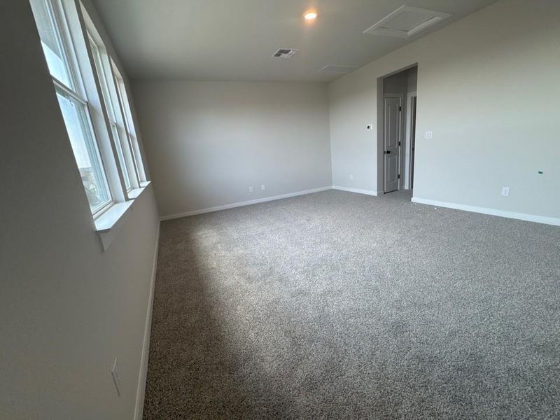 Empty room featuring carpet and attic access Empty room featuring carpet and attic access