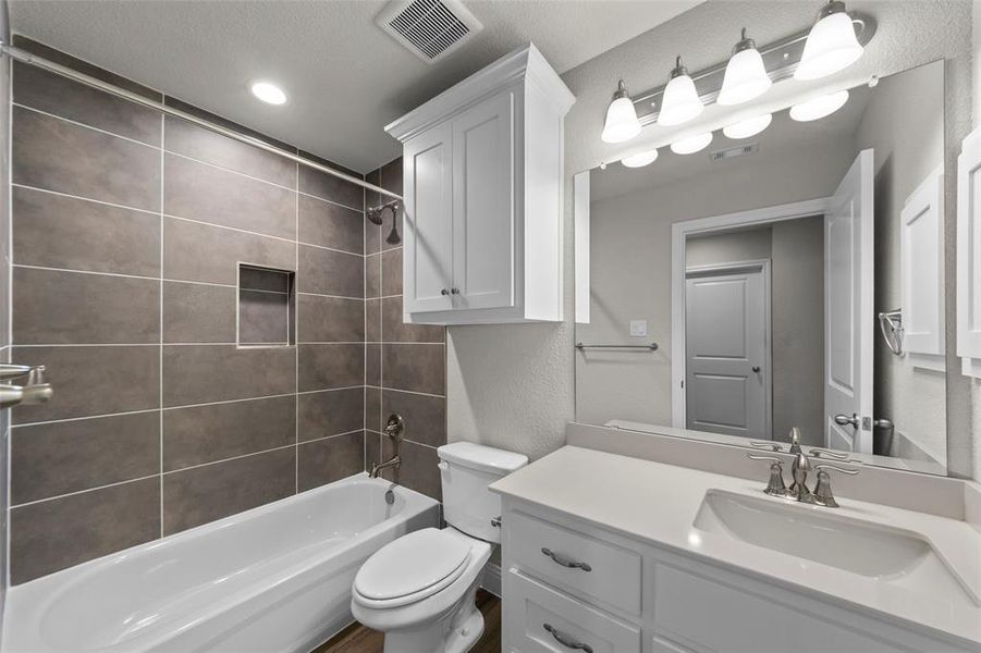 Bathroom featuring a white vanity with an integrated sink and brushed nickel faucet, a large mirror, and a five-light fixture