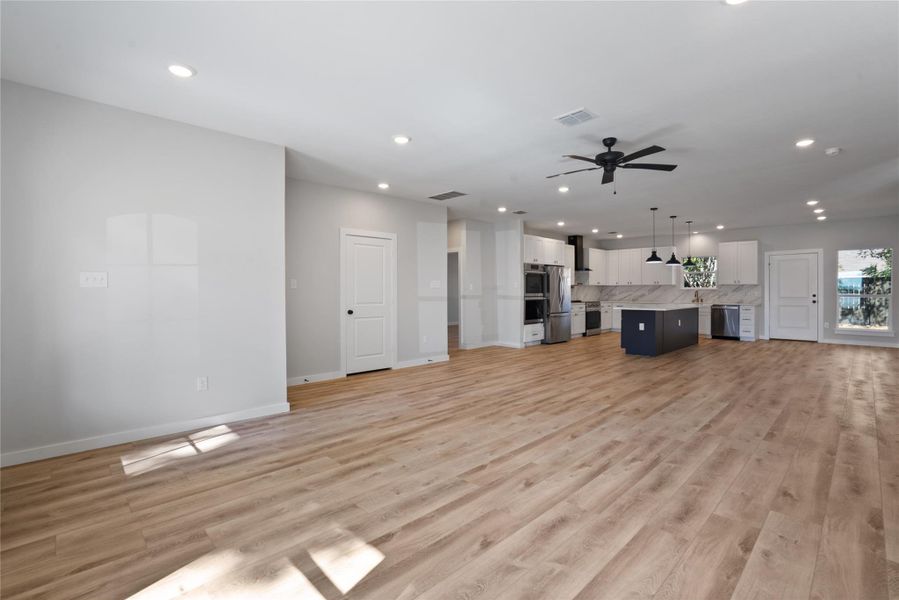 Unfurnished living room with light wood finished floors, recessed lighting, and a ceiling fan
