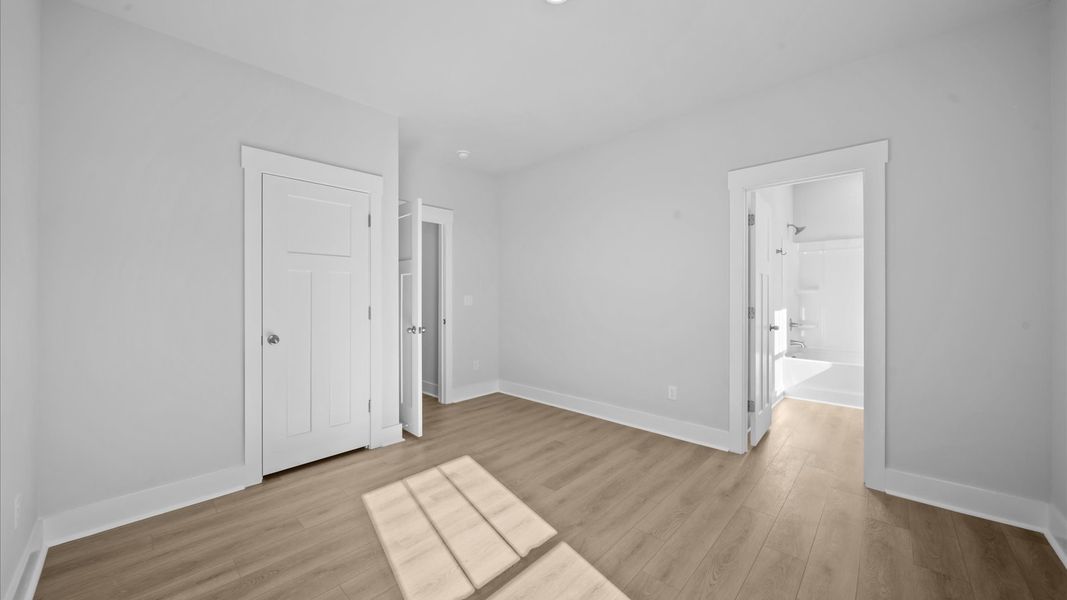 Elegant hardwood floors extend into spacious, light-filled secondary bedrooms