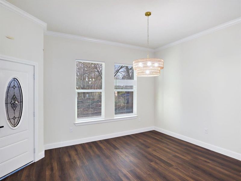 Foyer entrance with crown molding and dark wood-type flooring Foyer entrance with crown molding and dark wood-type flooring