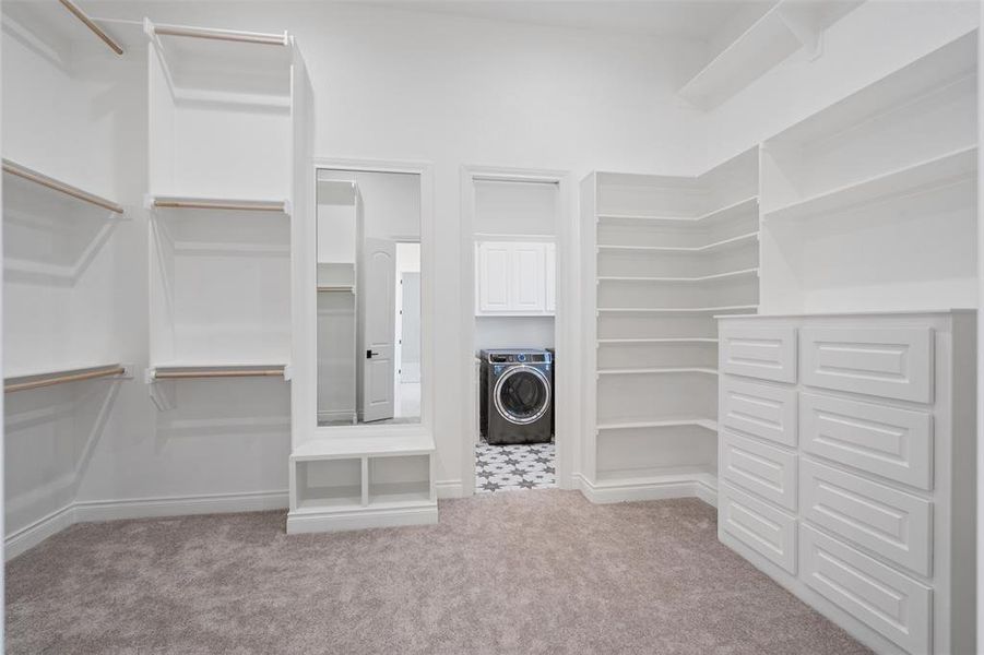 Spacious closet featuring light carpet and washer / dryer