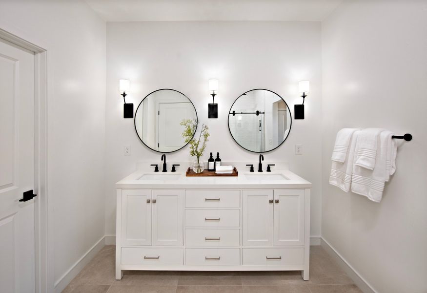 Primary bath with freestanding vanity and circular mirrors Primary bath with freestanding vanity and circular mirrors