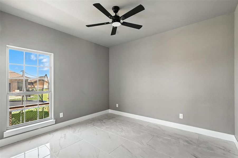 Spare room with light marble finish flooring and ceiling fan Spare room with light marble finish flooring and ceiling fan