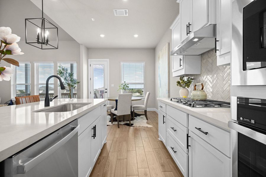 Kitchen featuring white cabinets, stainless steel appliances, light stone counters, healthy amount of natural light, and recessed lighting