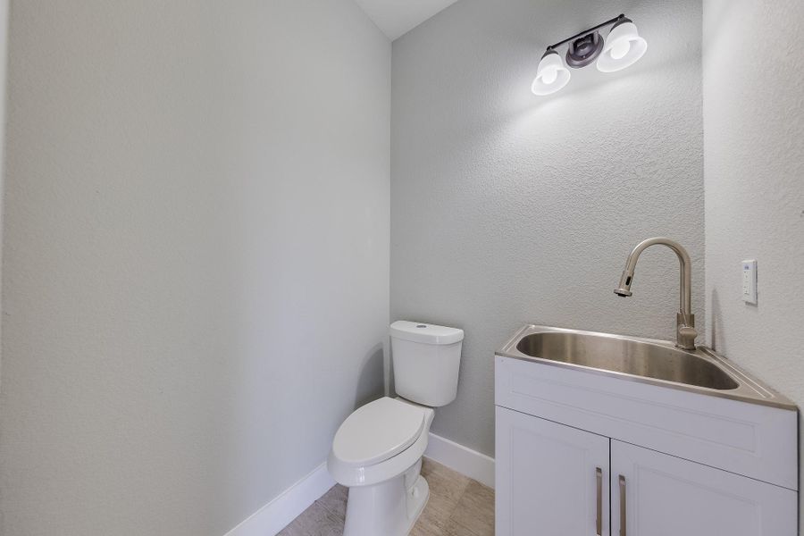 Mudroom or half bath conveniently located at the back patio, offering easy access and functionality for outdoor activities. Mudroom or half bath conveniently located at the back patio, offering easy access and functionality for outdoor activities.