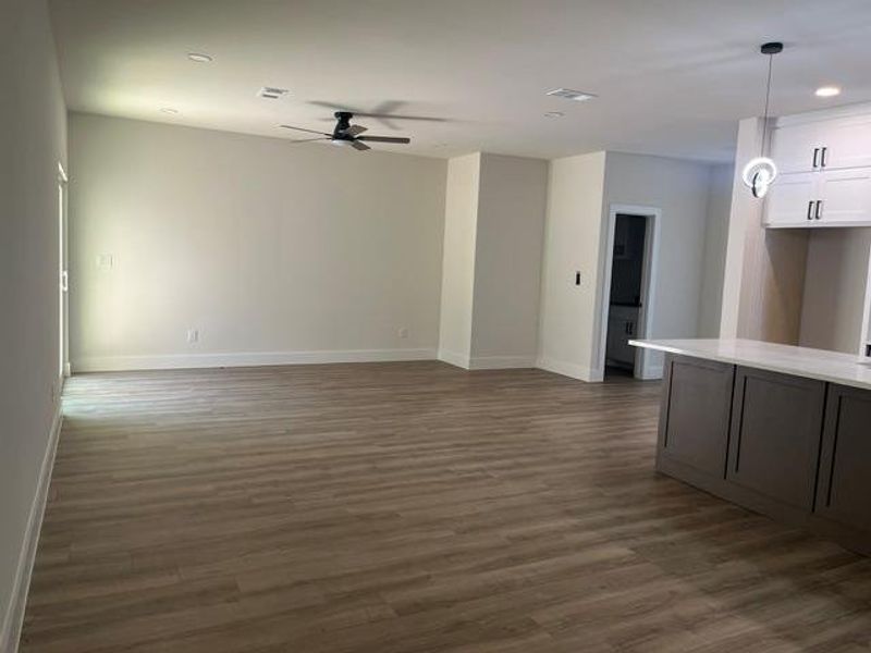 Open concept living area featuring wood-finish flooring, recessed lighting, and a contemporary ceiling fan Open concept living area featuring wood-finish flooring, recessed lighting, and a contemporary ceiling fan