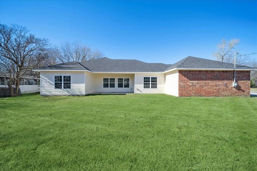 Rear view of house featuring a yard