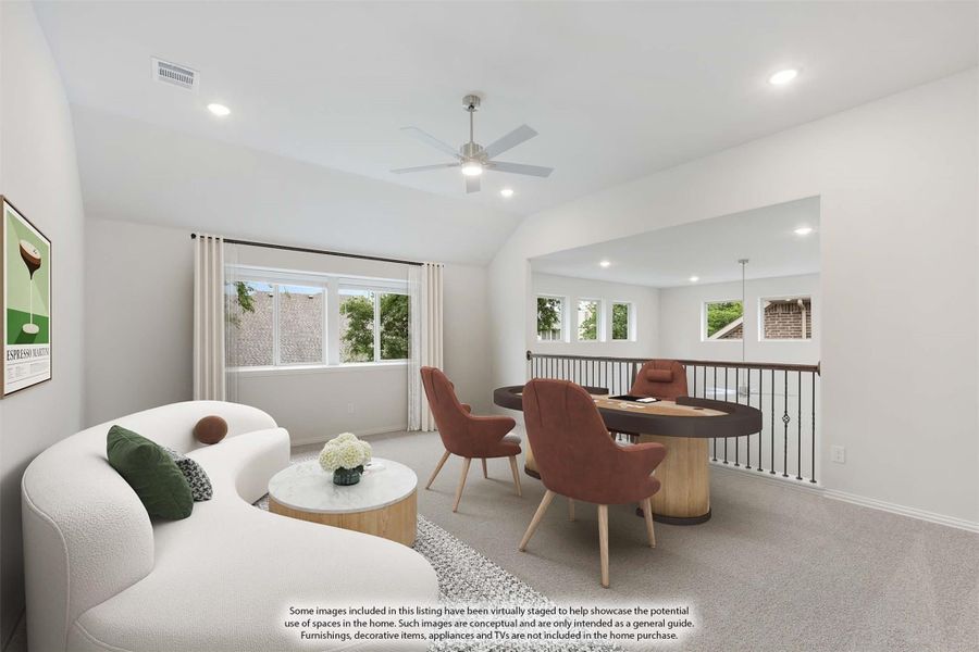 Upstairs loft with sitting area, round dining table, ceiling fan, and open railing overlooking staircase Upstairs loft with sitting area, round dining table, ceiling fan, and open railing overlooking staircase