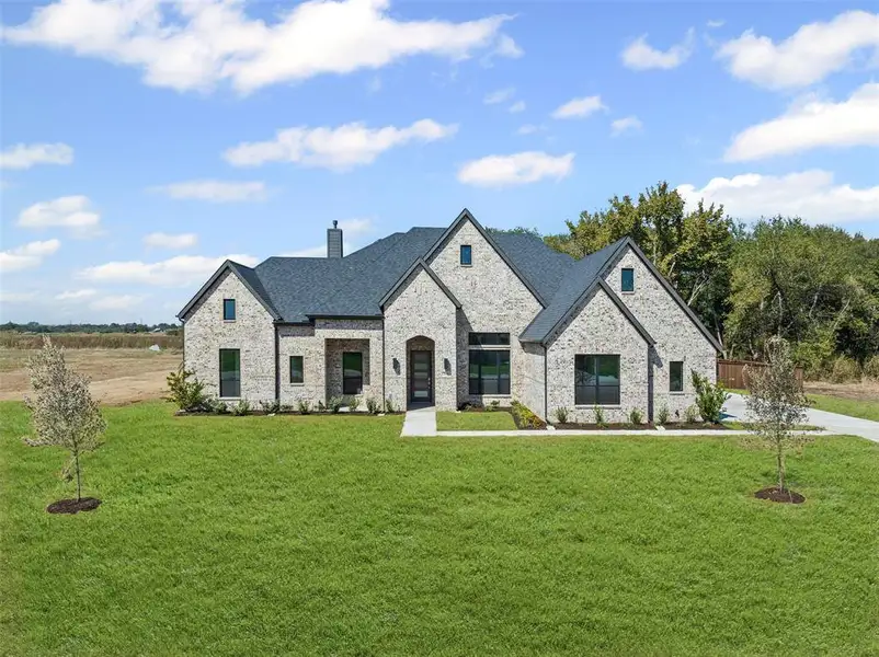 Front exterior of a new home in Waterfall Ranch - 1 Acre Lots, Waxahachie, TX, highlighting curb appeal (Image 1).