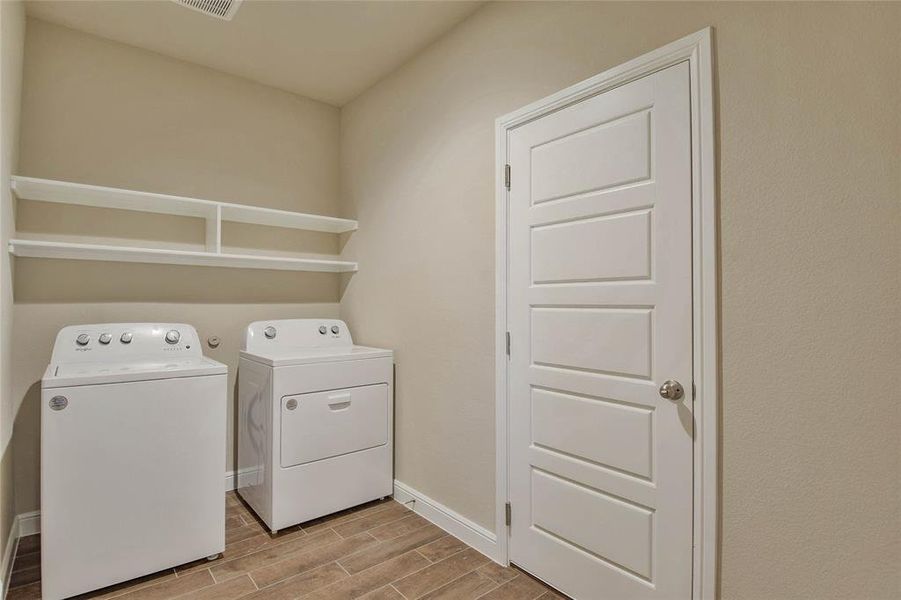 Washroom with independent washer and dryer and wood tiled floors Washroom with independent washer and dryer and wood tiled floors