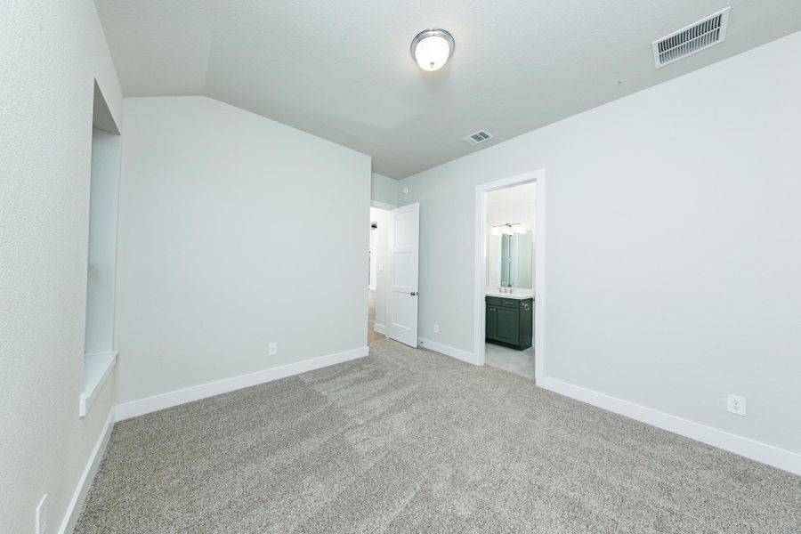 This inviting secondary bedroom would make a wonderful guest suite! Featuring a soft neutral color palette, large window, walk-in closet, and an ensuite secondary bathroom.